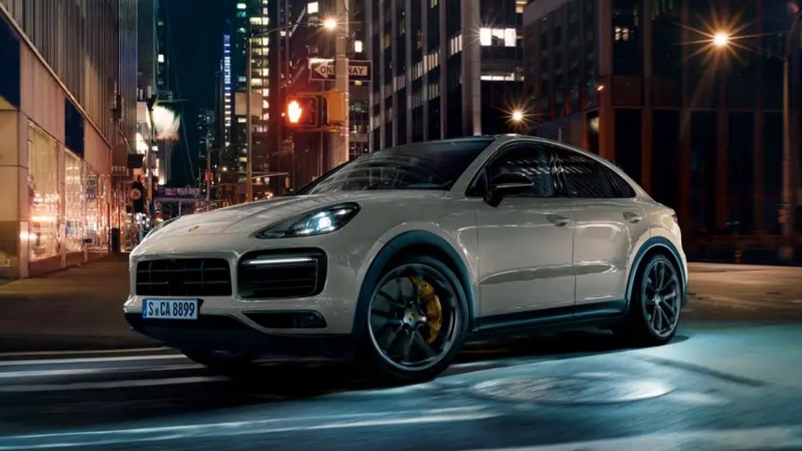 A white 2022 Porsche Cayenne GT Turbo is driving on the road.