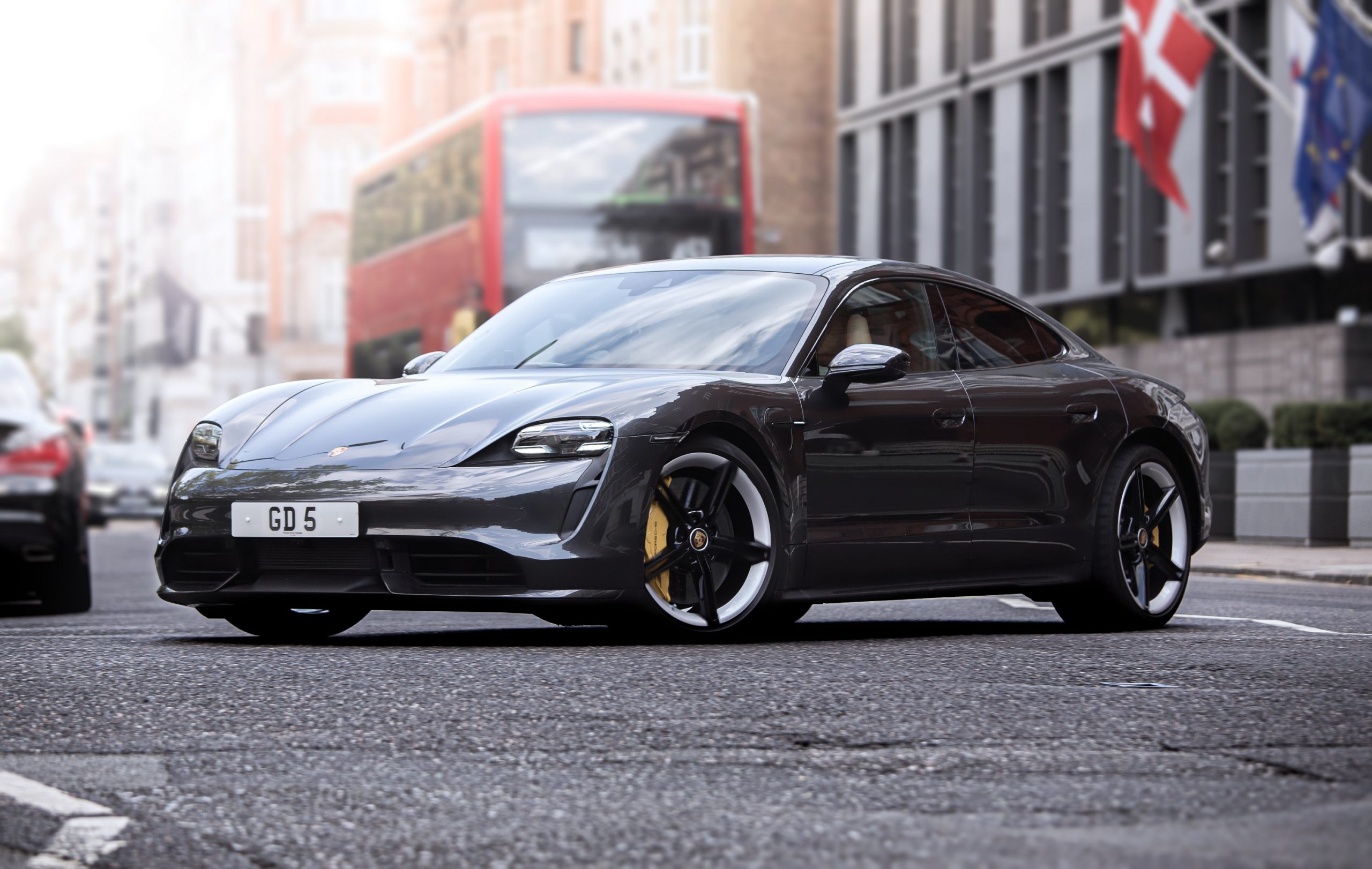 A black Porsche Taycan Turbo S EV shot from the 3/4 angle on a London street