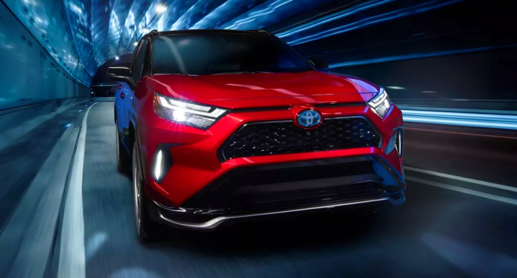 A red Toyota RAV4 Prime plug-in hybrid SUV is driving through a tunnel. 