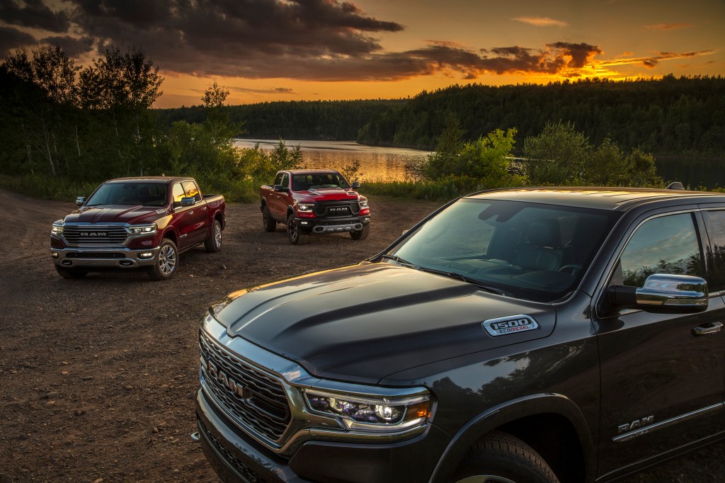 Several 2022 Ram 1500 trucks parked by a pond.