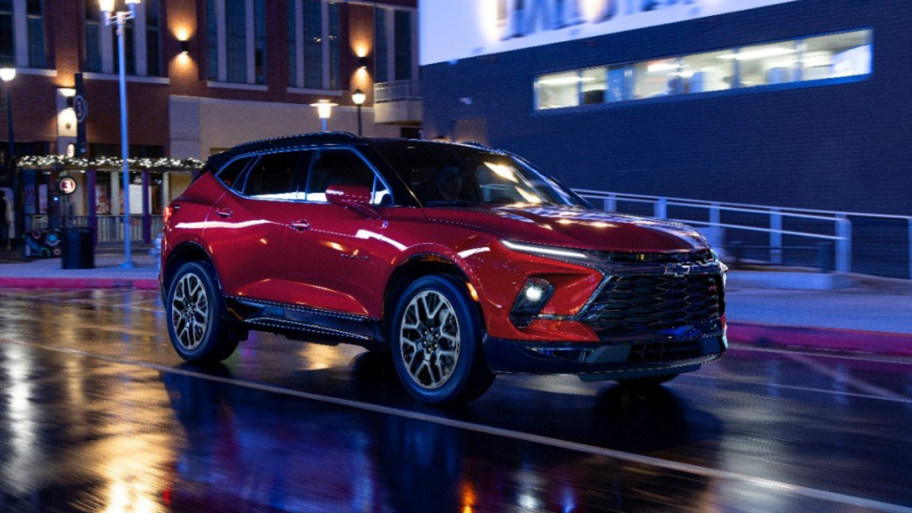 Radiant Red Metallic 2023 Chevy Blazer RS driving on a street at night