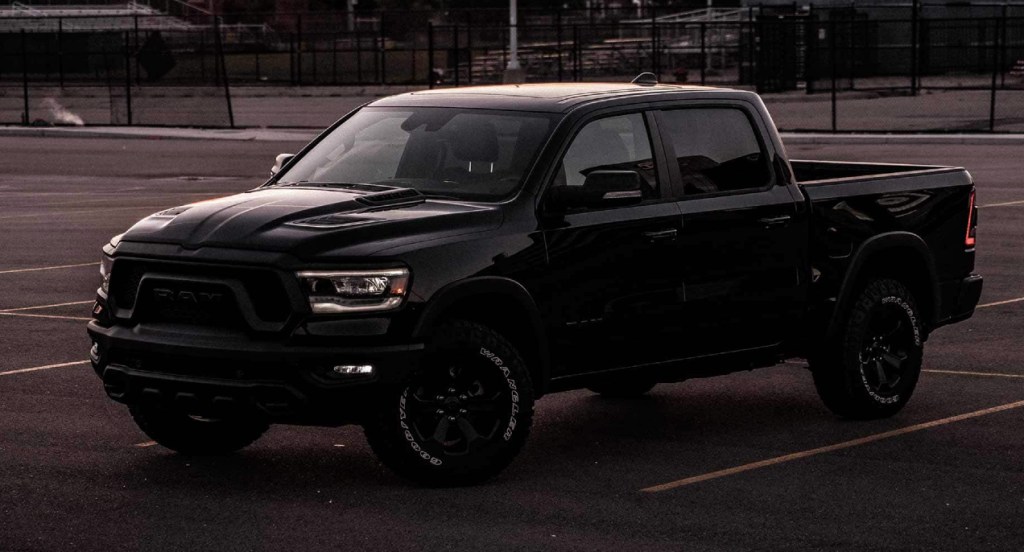 A black Ram 1500 full-size truck is parked in a parking lot. 
