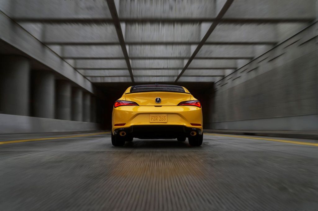 Rear view of yellow 2023 Acura Integra, highlighting its release date and price