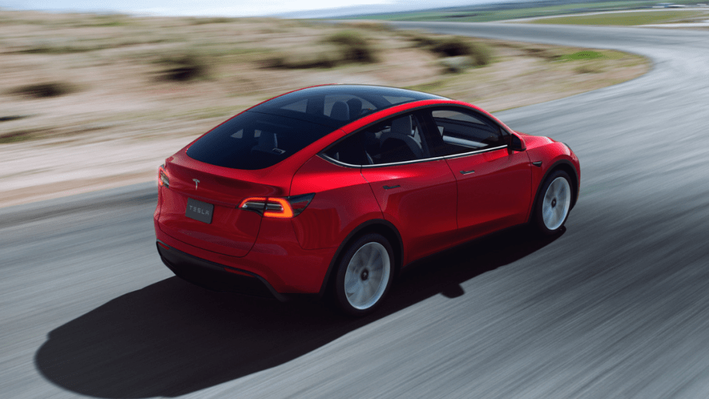 Red Multi-Coat 2022 Tesla Model Y driving on a curvy road
