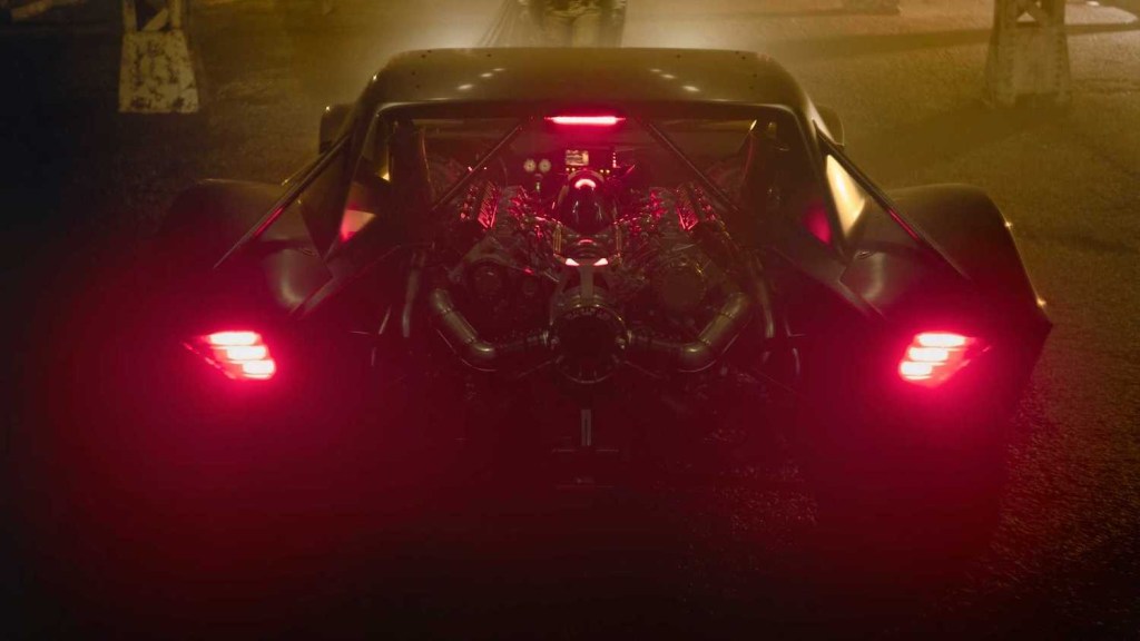 Detail shot of the large engine of the new batmobile sitting atop the trunk, between glowing tail lights.