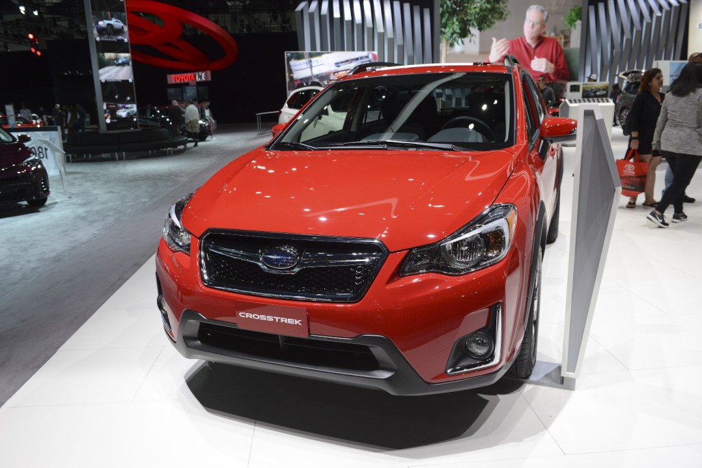 A Subaru Crosstrek AWD SUV in red, featured at an auto show.