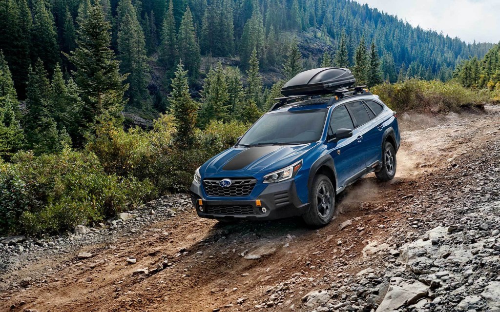 A blue 2022 Subaru Outback in the woods. 