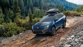 A blue 2022 Subaru Outback in the woods.