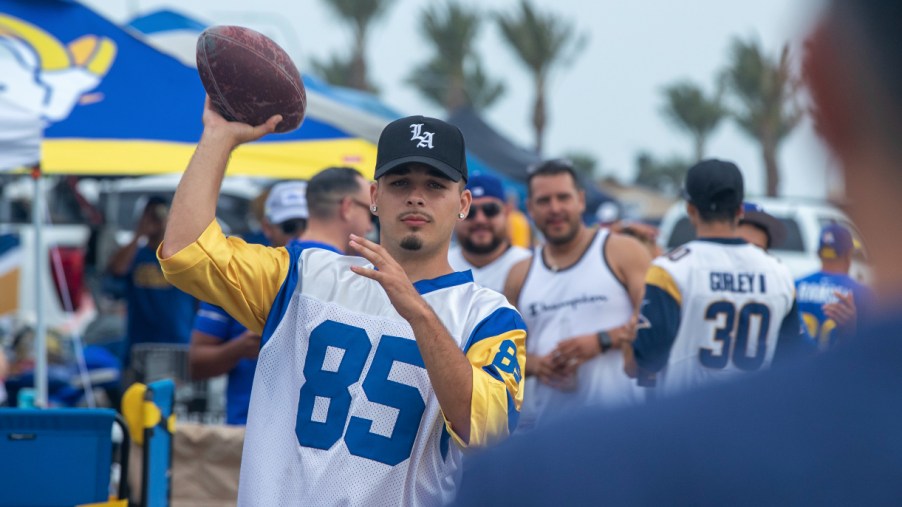Man throwing ball at a tailgate party.