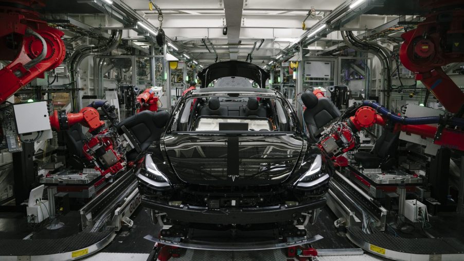 Robots assemble a Tesla Model 3 in one of the brand's factories