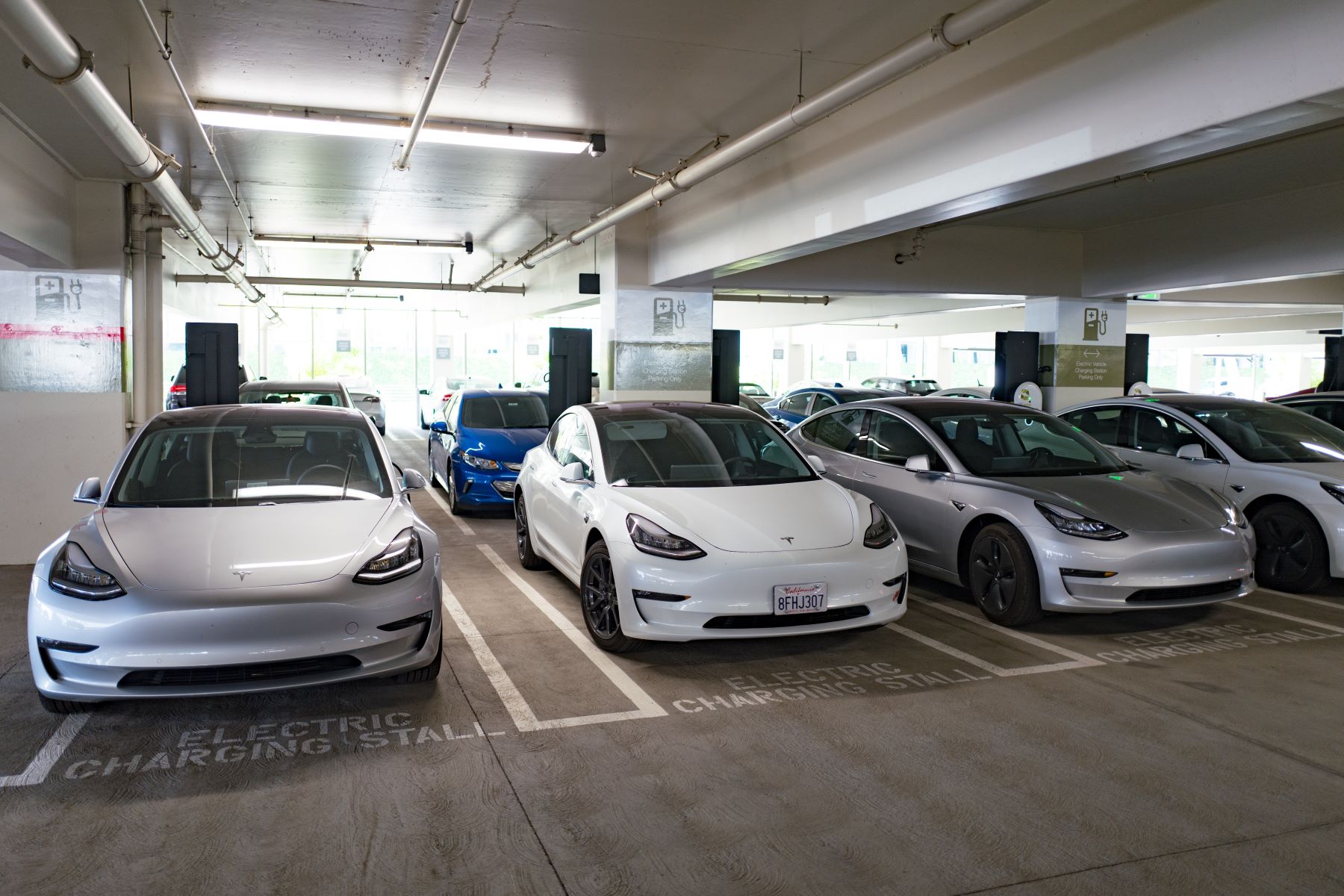 Tesla Model 3 cars charging inside a parking garage in San Ramon, California