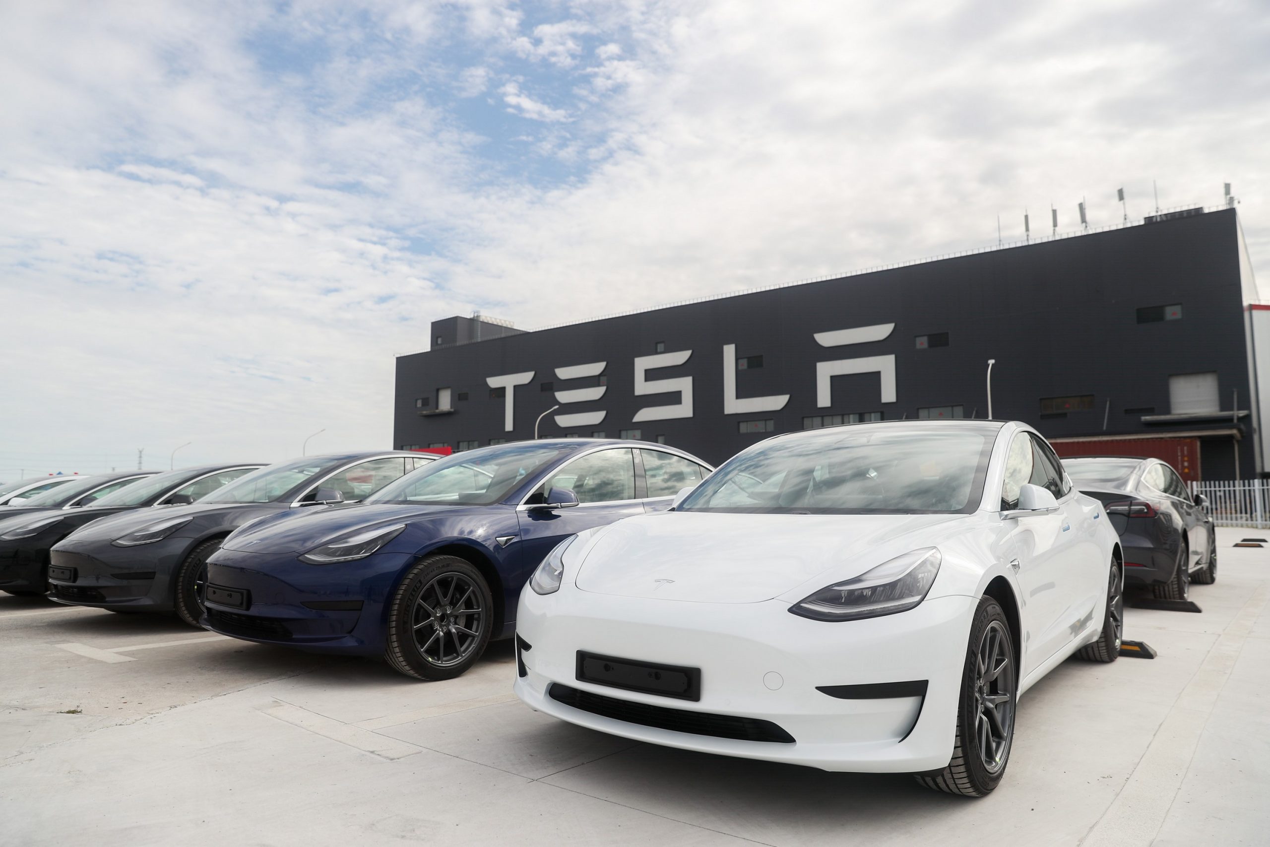 A group of Tesla Model 3 EVs outside one of the brand's factories