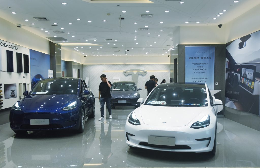 A blue and a white Tesla Model 3 in a Chinese dealer during a recall
