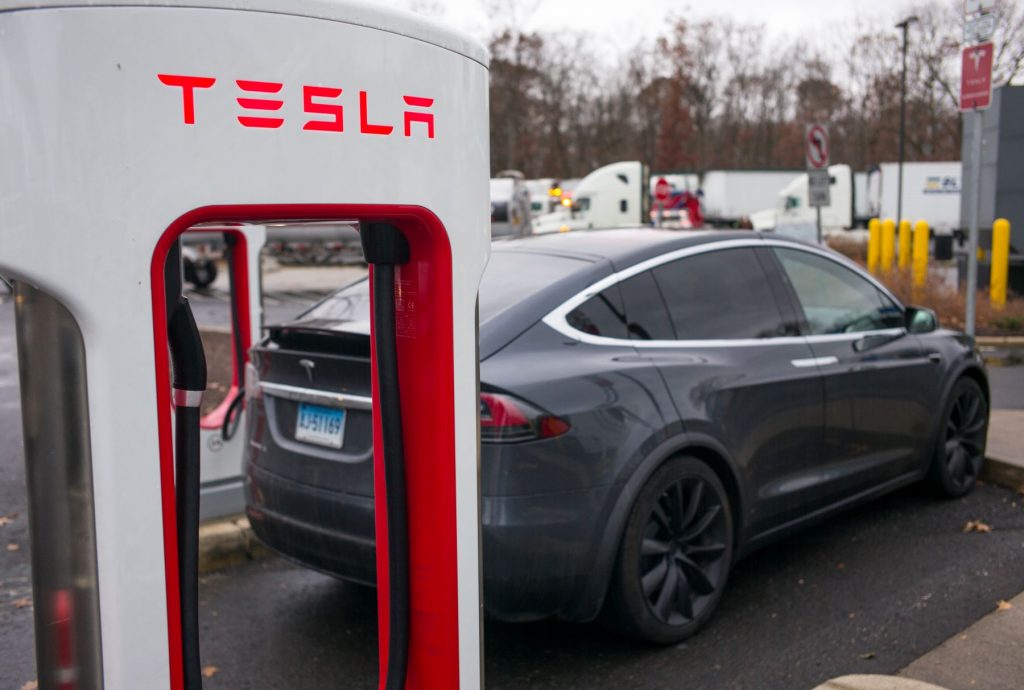 A Tesla Model X EV charging at a Tesla electric charging station of driving range miles