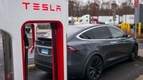A Tesla Model X EV charging at a Tesla electric charging station of driving range miles