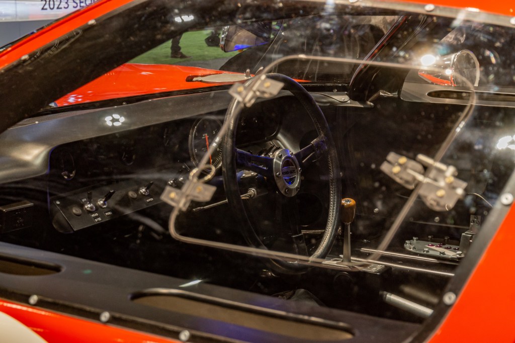 The 1966 Ford GT40 Mk I Lightweight 'AM GT-1''s steering wheel, dashboard, and shifter seen through its side window