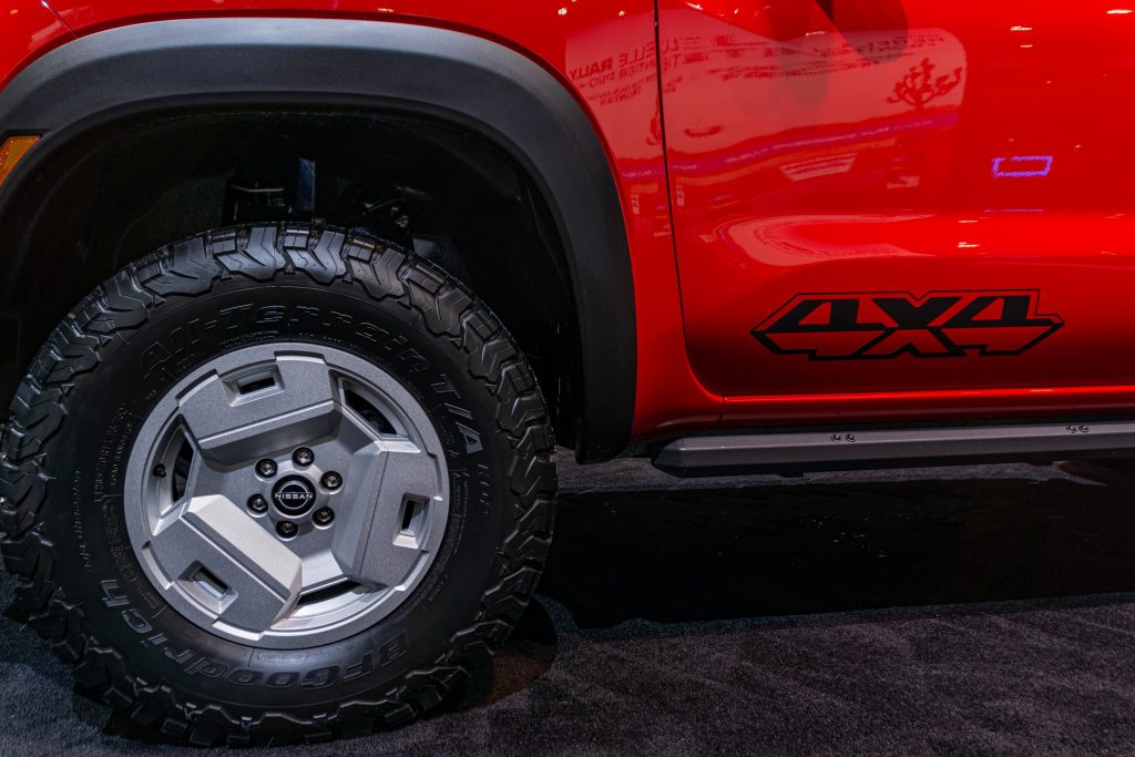 The red-and-black 2022 Nissan Frontier Project Hardbody's front wheel and red-and-black side graphic