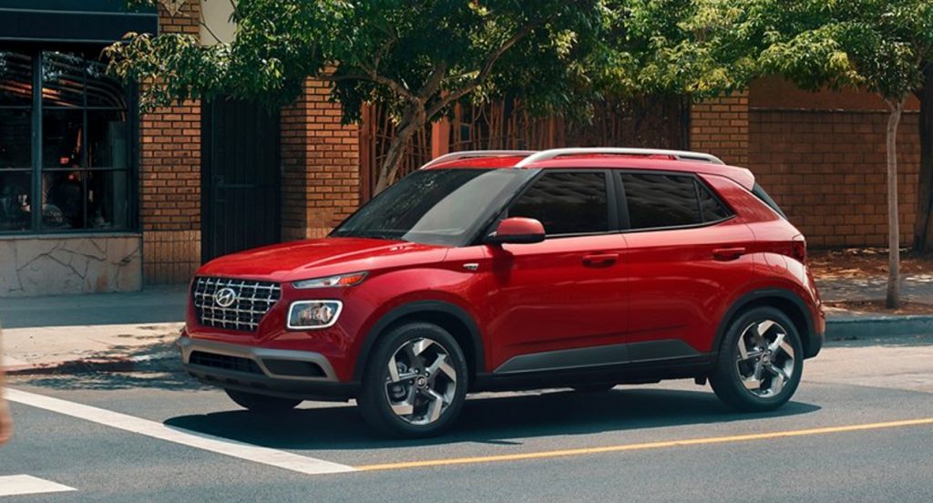 A red Hyundai Venue Limited subcompact SUV is at a stop light. 