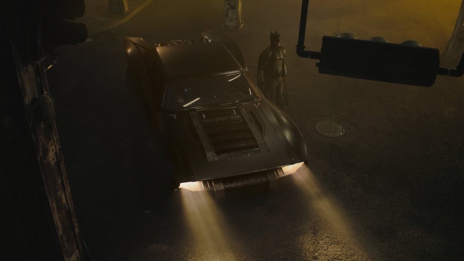 A birds-eye view of batman and the muscle-car based new batmobile in an intersection.