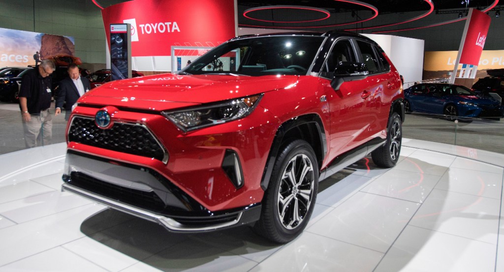 A red Toyota RAV4 Prime plug-in hybrid SUV is on display.