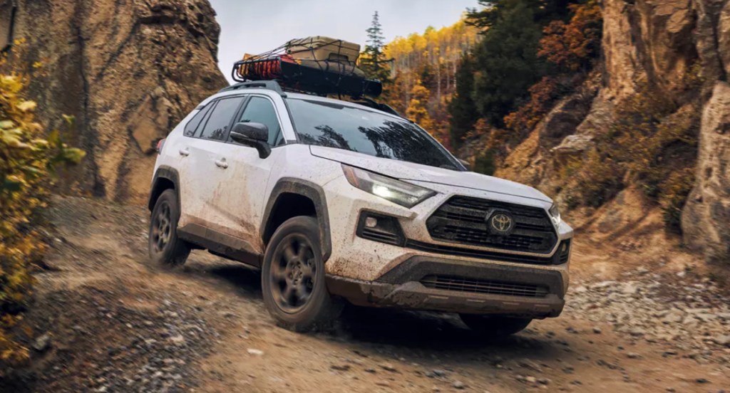 A white 2022 Toyota RAV4 compact SUV is driving off-road. 