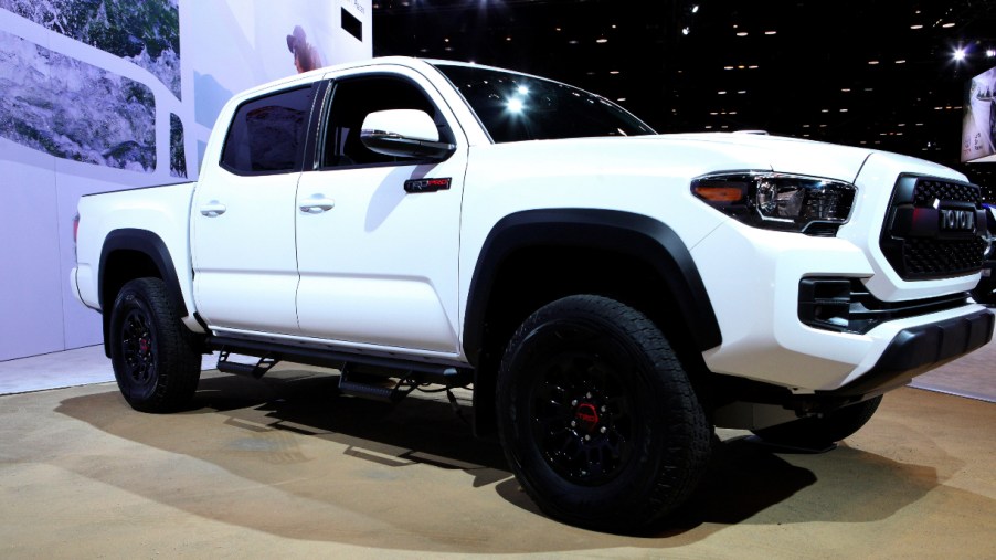 A white Toyota Tacoma midsize pickup truck is on display.