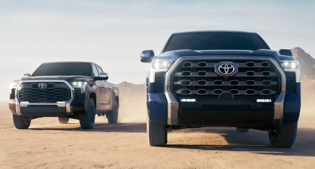 A black (L) and blue (R)Toyota Tundra pickup truck driving side by side. 