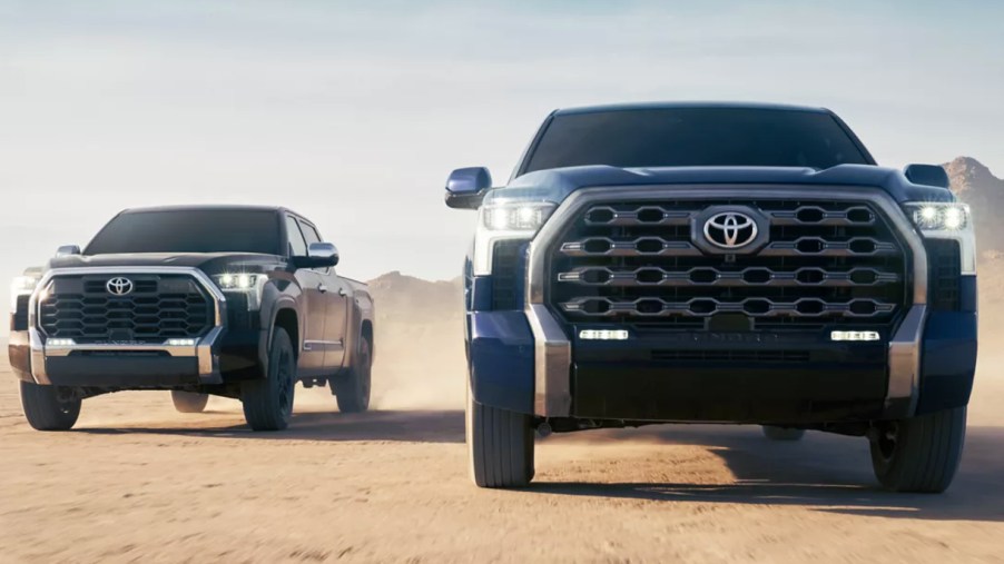 Two Toyota Tundra pickup trucks driving side by side.