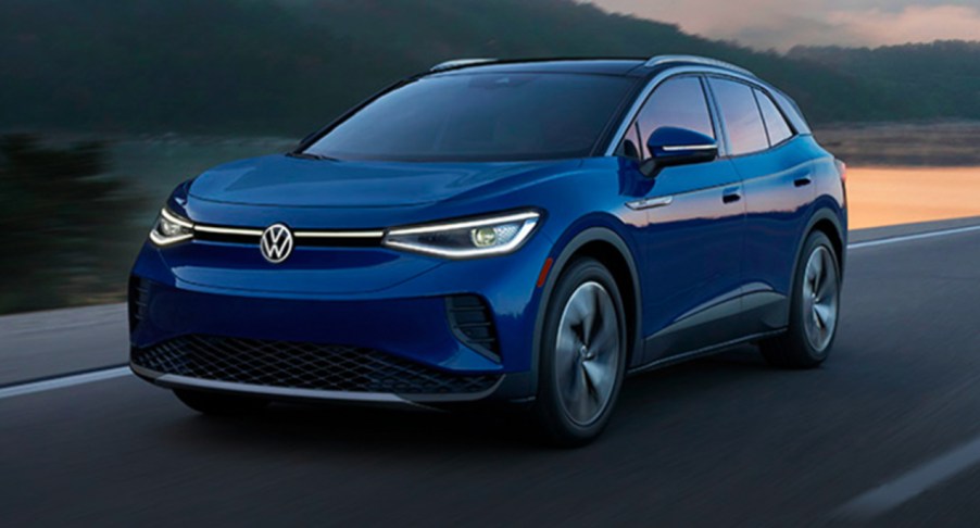 A blue 2022 Volkswagen ID. 4 electric SUV is driving on the road.