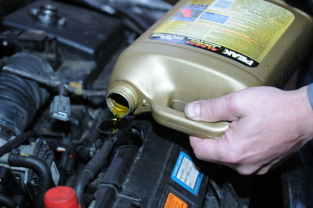 man adding coolant to a car