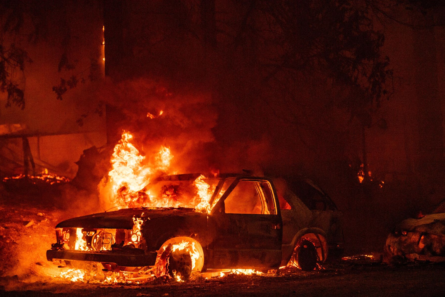 A car on fire in the Indian Falls neighborhood of Plumas County, California during the spread of the Dixie fire