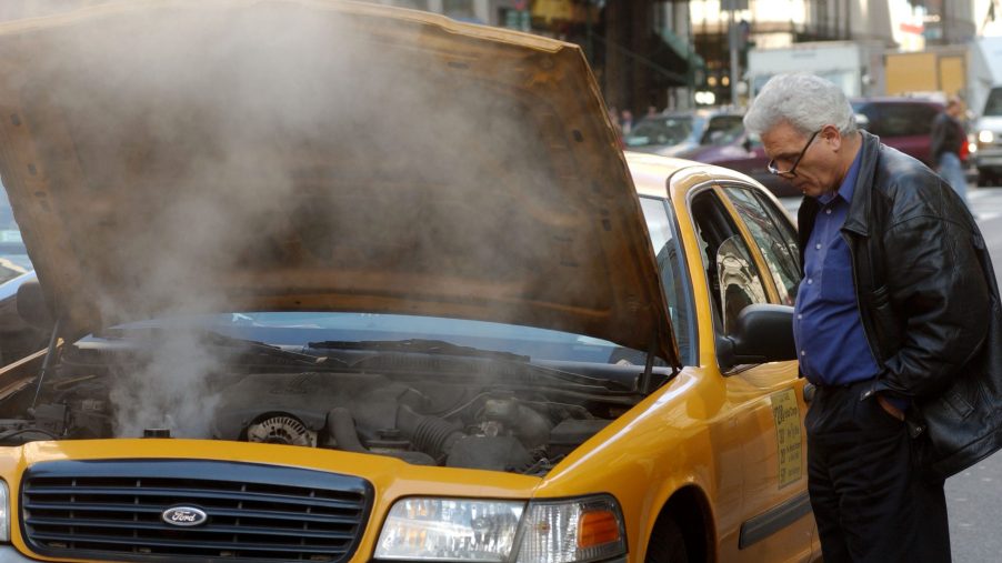 taxi cab overheats shooting steam out from under the hood. This is why you should flush your coolant system