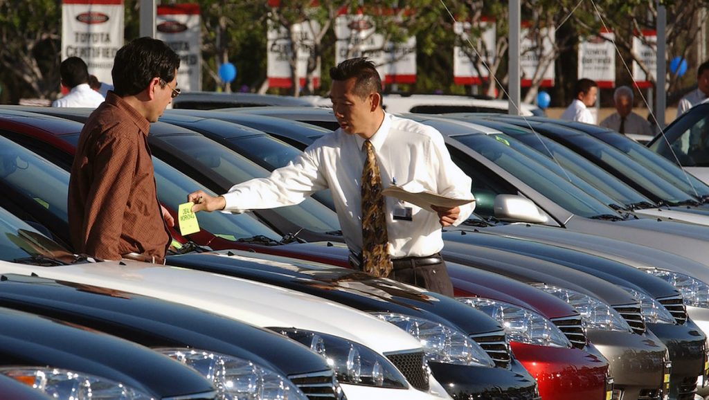 Car salesperson Victor Zeng (right) assists customer Gary Zhao at a Toyota dealership in El Monte, California