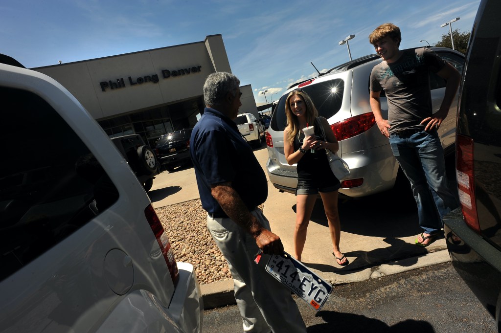 A salesperson sells a car to customers.