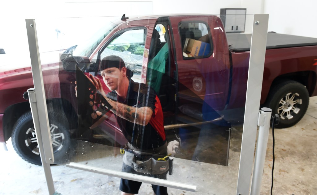 A tint installer makes the final trimming to the glass tint.