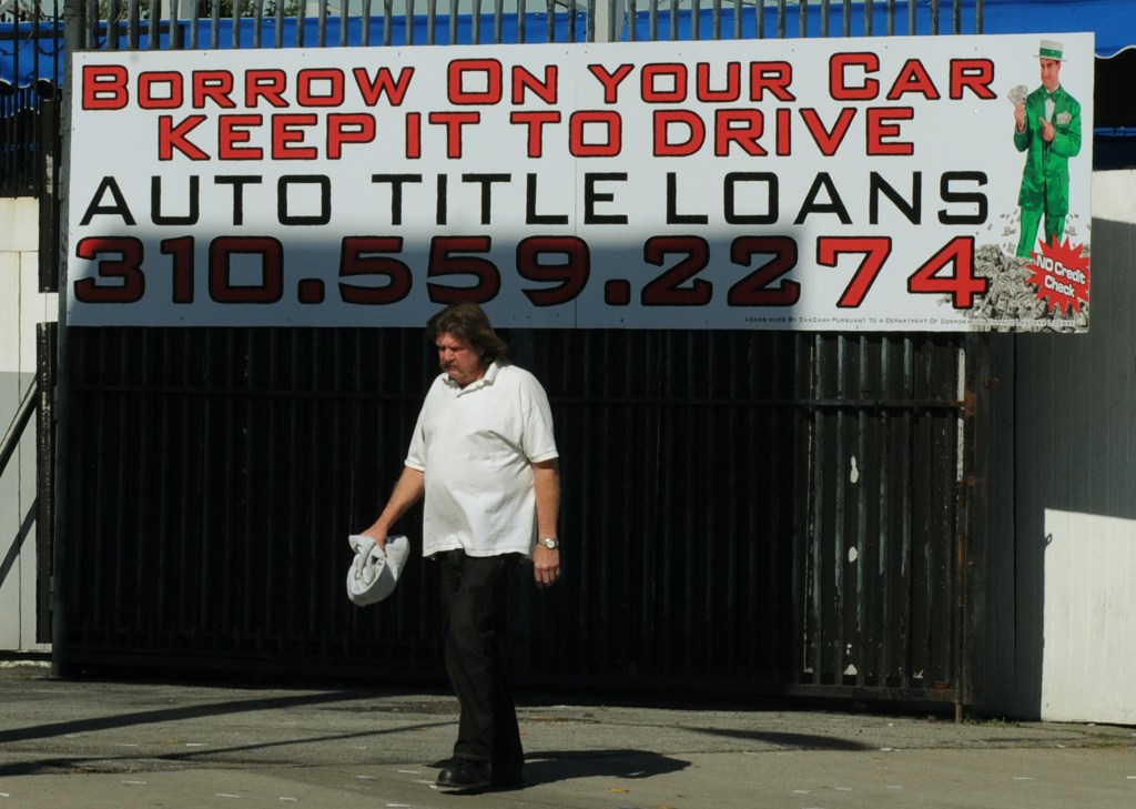 A man walks past a firm offering car title loans.