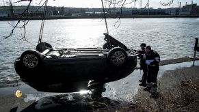 A crane pulling a car from the Meuse River in Liege, Belgium for a missing persons case