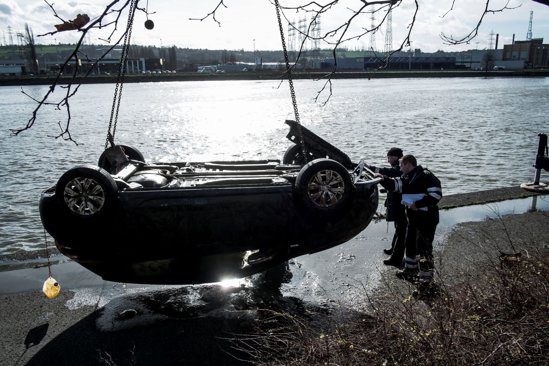 A crane pulling a car from the Meuse River in Liege, Belgium for a missing persons case