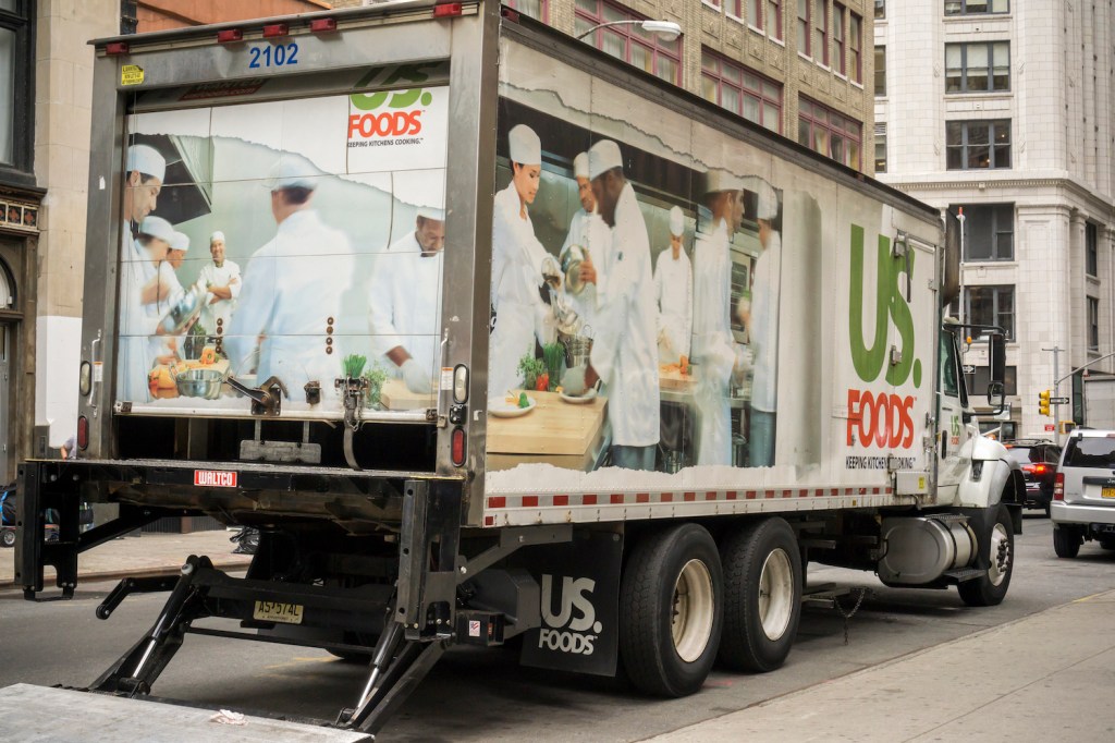 A food delivery truck parked in New York's flatiron district with its liftgate down.