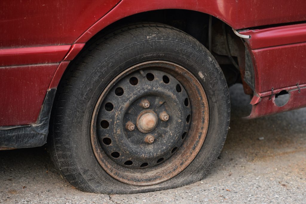 A view of a flat tire in a car parked in the center of Krakow.