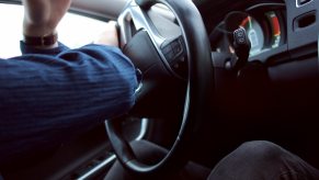 Closeup of a driver's hands steering a car.