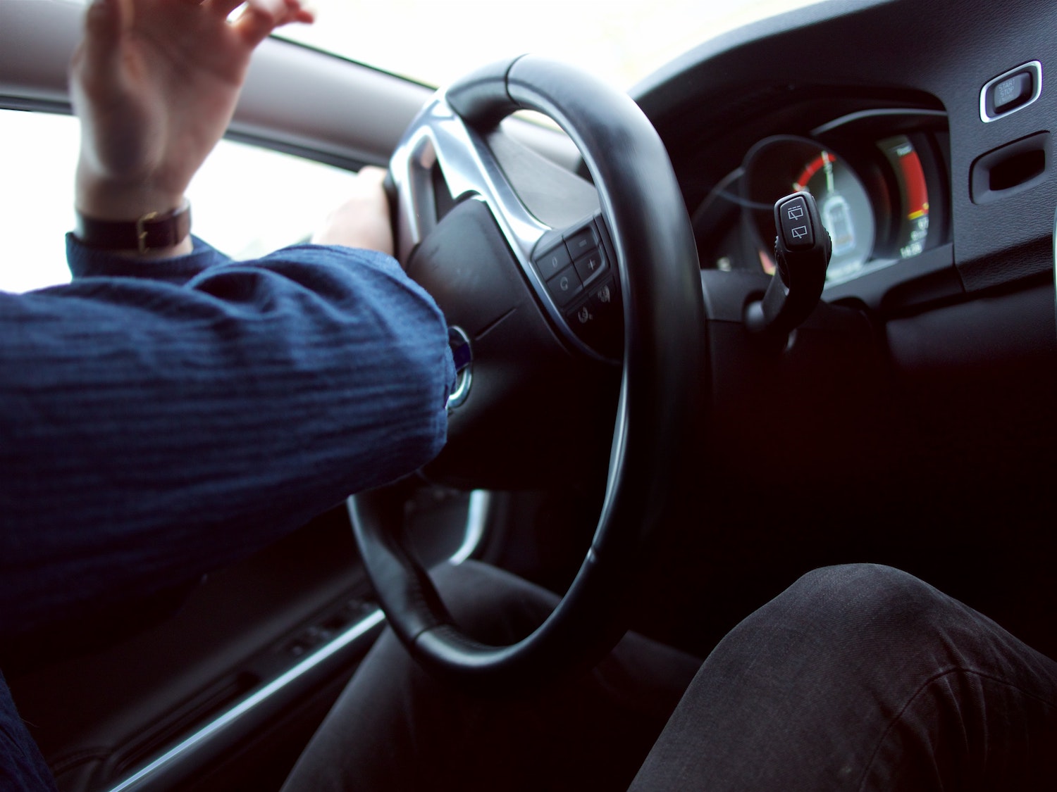 Closeup of a driver's hands steering a car.