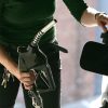 A woman pumps fuel into her car