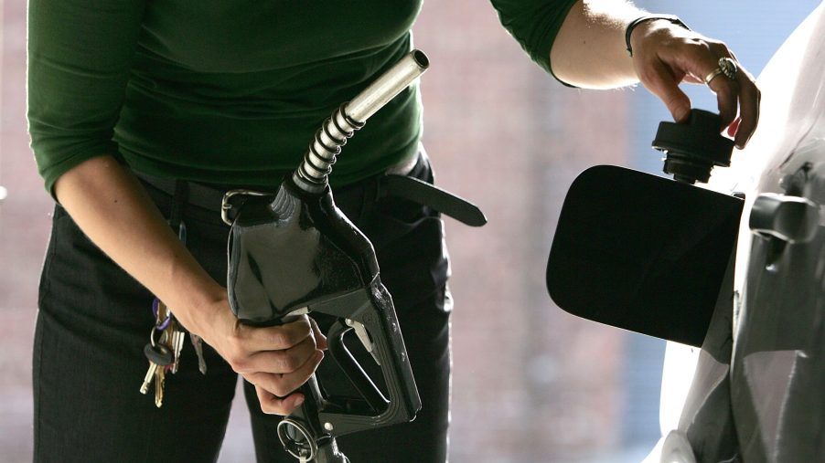 A woman pumps fuel into her car