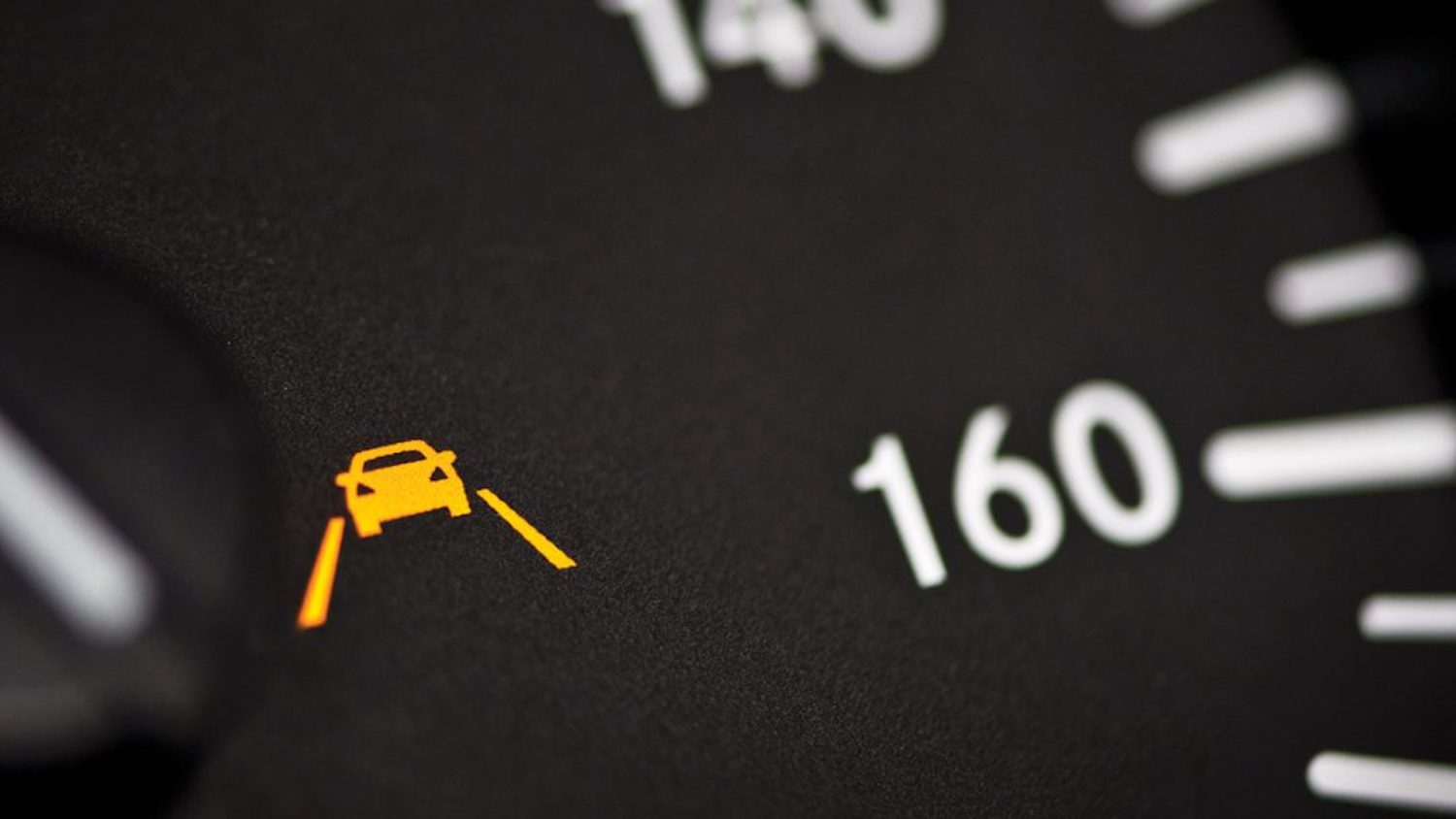 Detail shot of a lane departure warning icon on a Mercedes dashboard. 