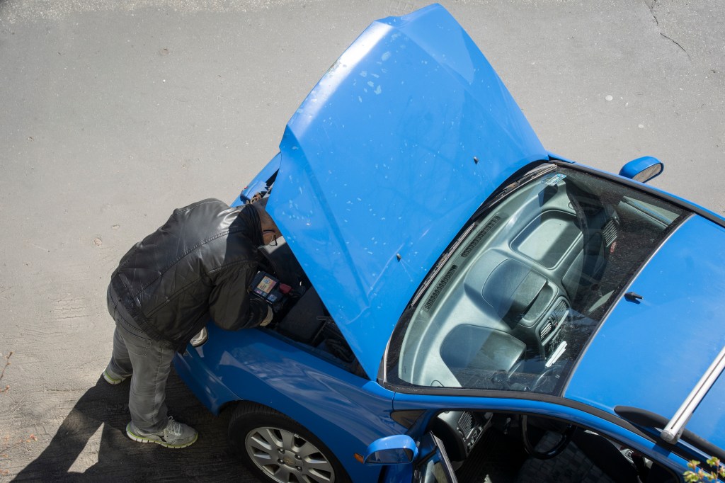 A man is seen working on a car in Warsaw, Poland. 