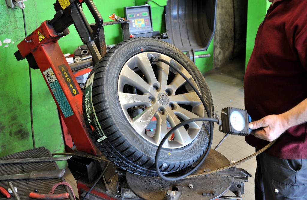 A mechanic fills air into an ice and snow tire. |