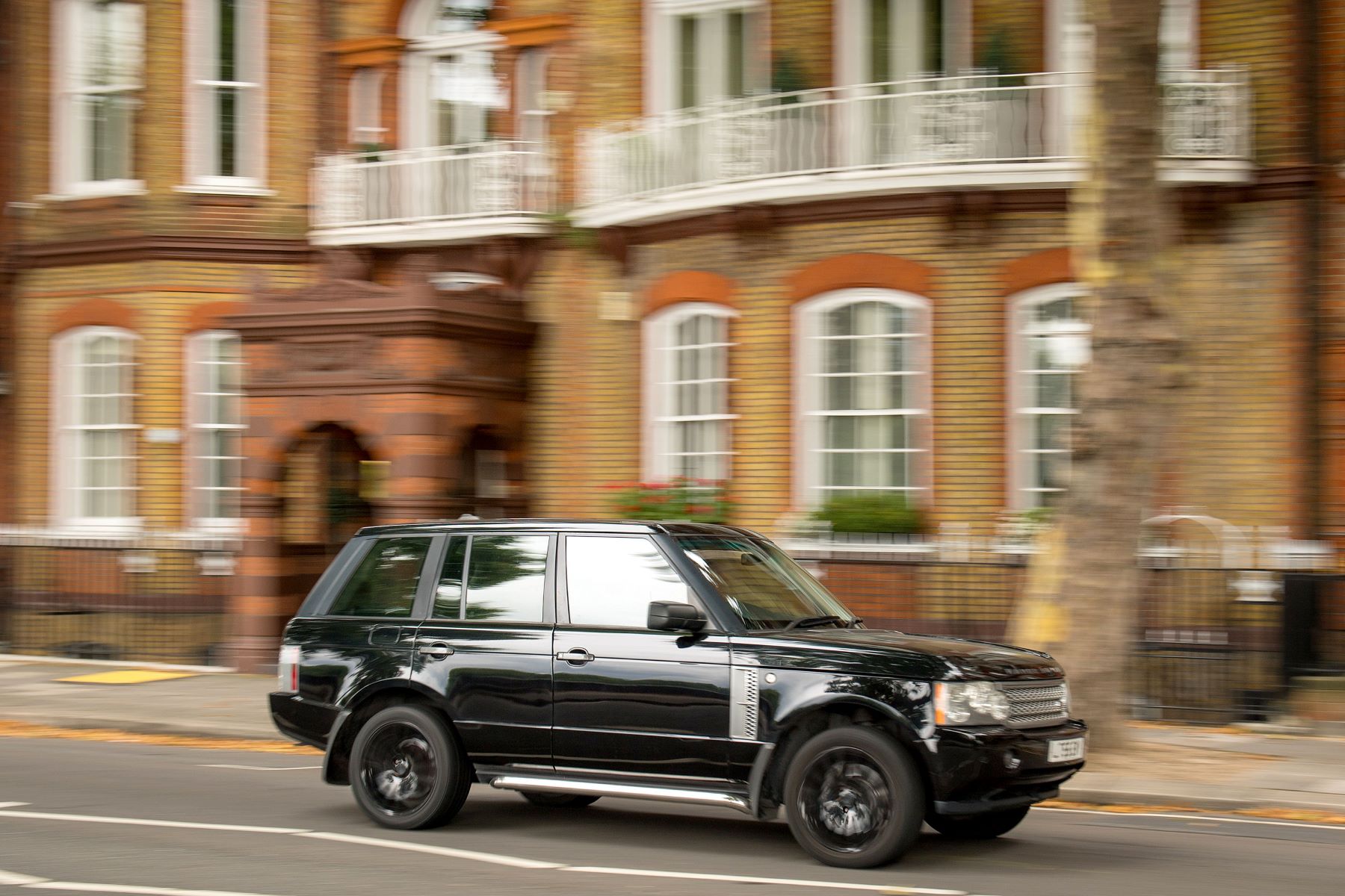 An old and used Land Rover Range Rover model driving in Chelsea of West London