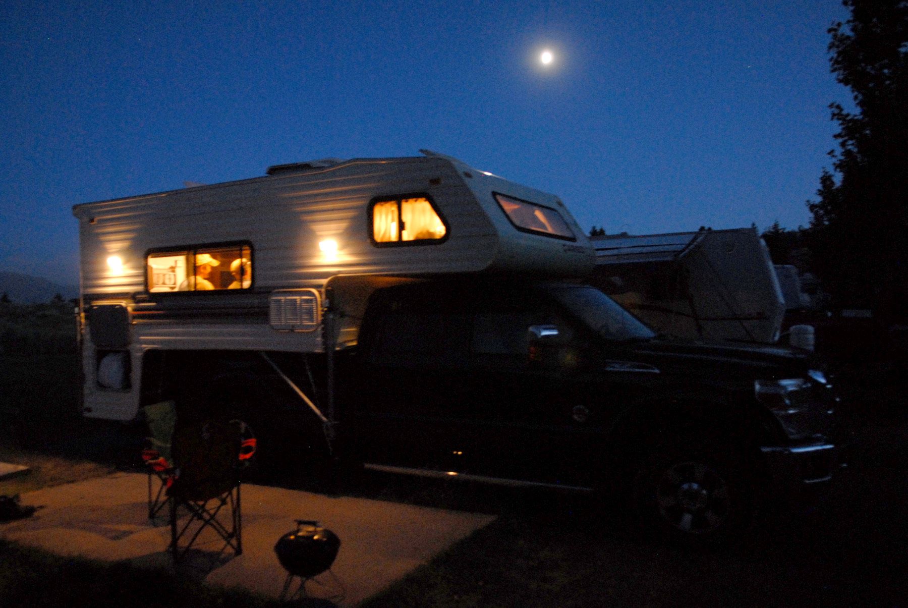 Campers repairing their RV at night in the Madison River Valley near Yellow Stone National Park