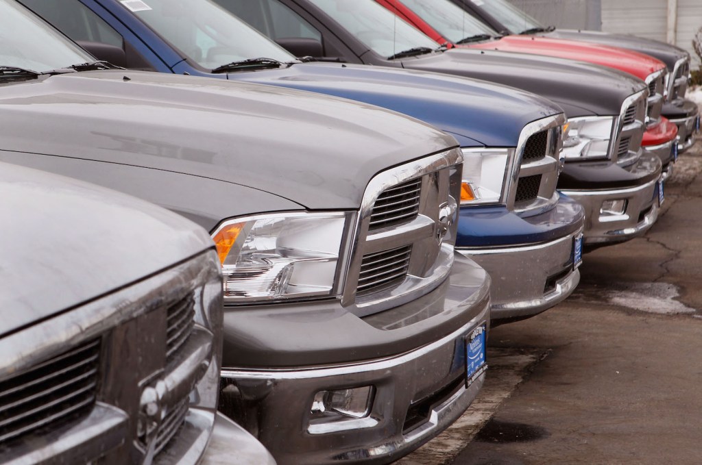 The grilles of a row of Ram trucks parked in a dealership lot.